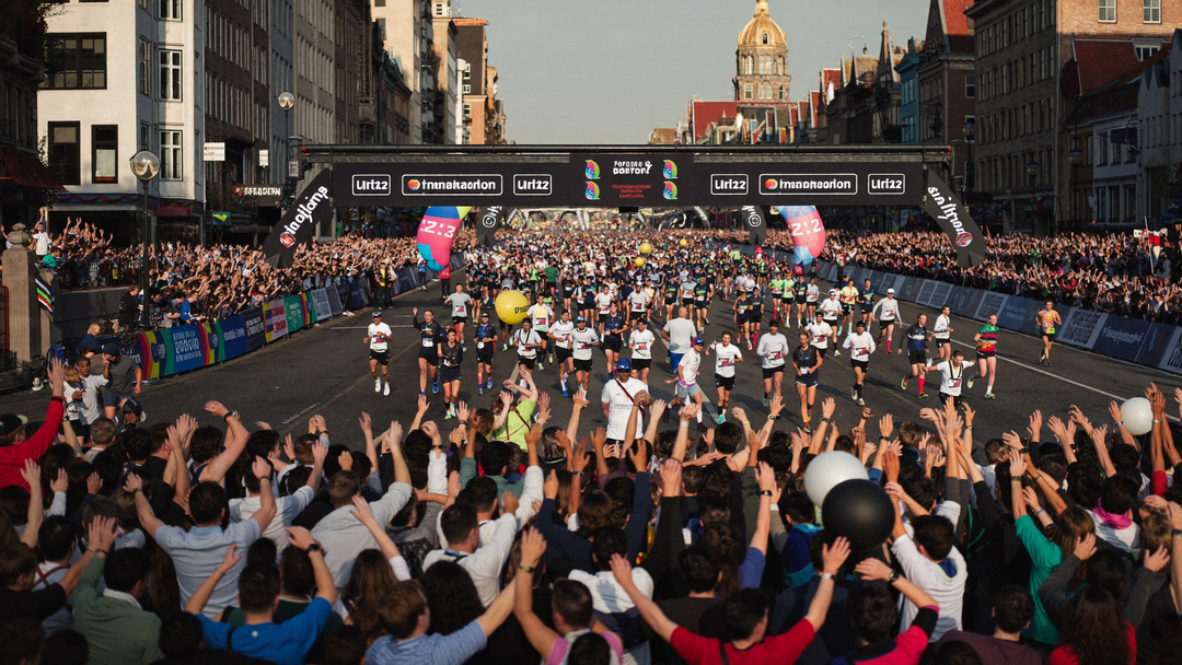 Marathonlopers vieren feest bij de finishlijn met aanmoedigend publiek